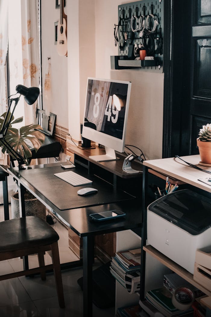 Stylish home office with computer, desk, and accessories creating a productive workspace.